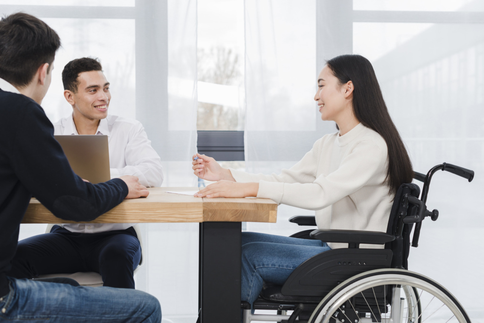 souriante jeune femme assise fauteuil roulant ayant reunion travail ses deux collegues